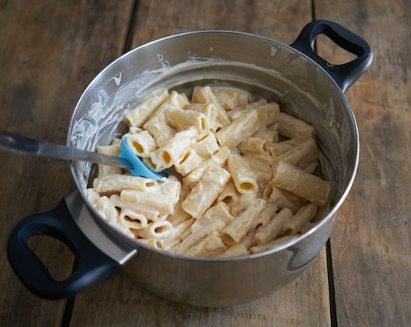 Schritt 10 Die Bechamelsauce zu den Nudeln geben und gründlich einarbeiten. Darauf achten, dass alles gut vermischt ist und die Nudeln innen und außen mit der Sauce bedeckt sind.