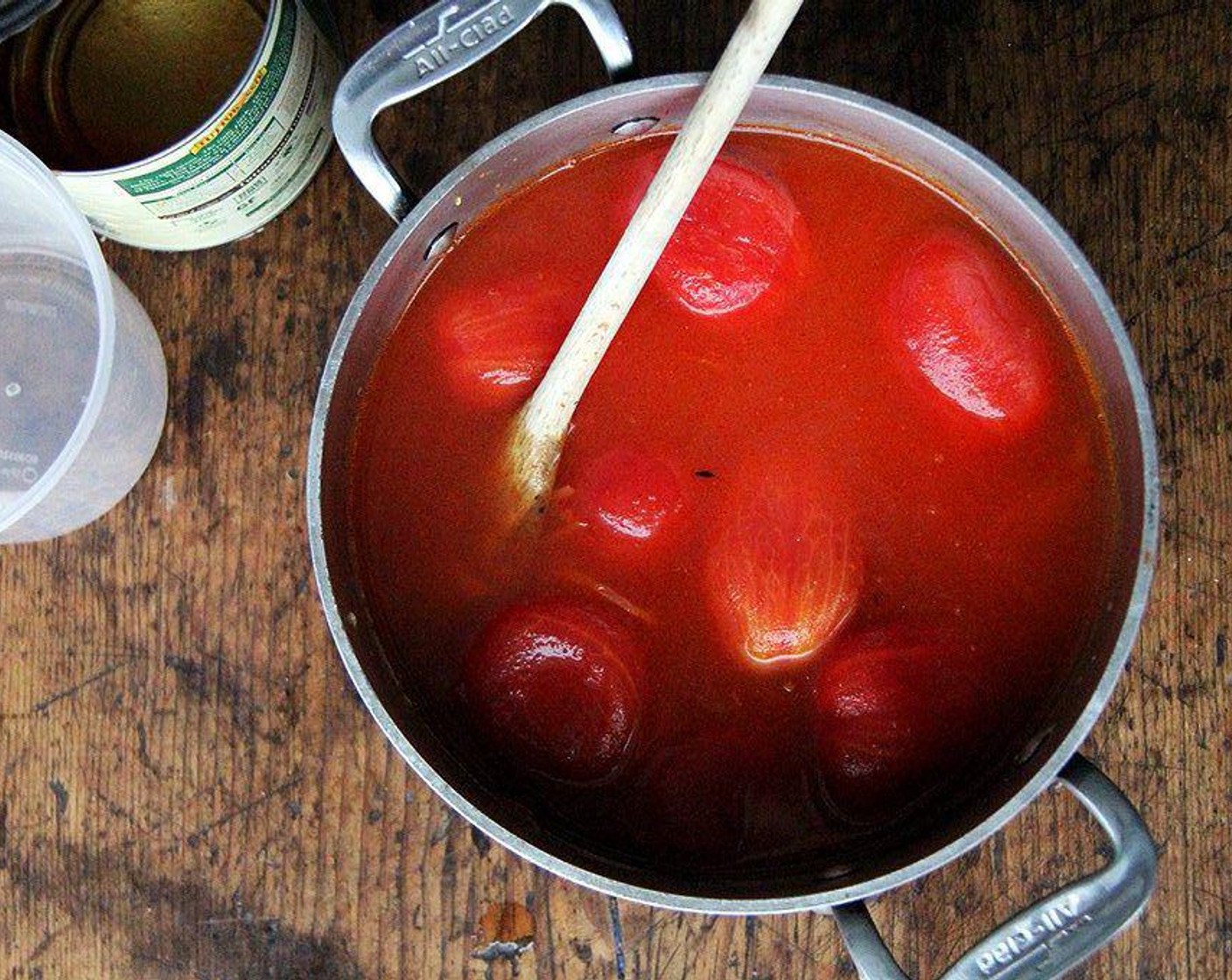 Schritt 3 Geschälte Tomaten (795 g) und Wasser (960 ml) in den Topf geben. Hitze erhöhen und zum Köcheln bringen. Sobald die Tomaten während des Kochens an die Oberfläche steigen, mit einer Schere zerteilen.
