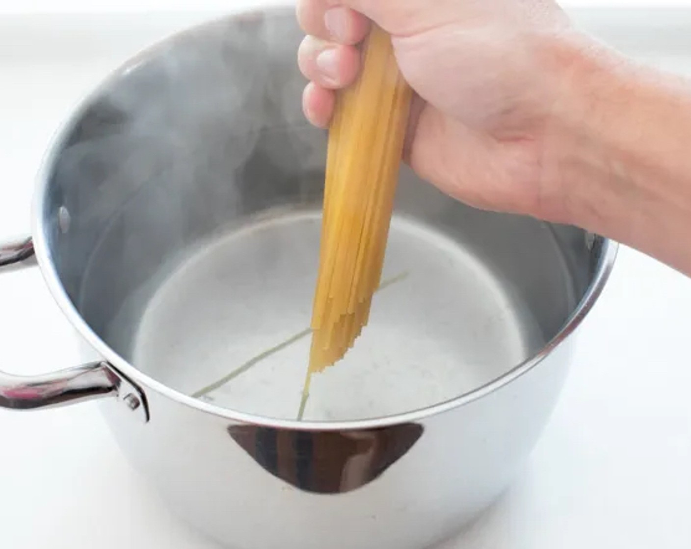 Schritt 1 Zunächst Spaghetti (1/2 Pck.) in Salzwasser nach Packungsanweisung al dente kochen. 1/2 Tasse des Nudelwassers aufbewahren und den Rest der Nudeln abgießen.