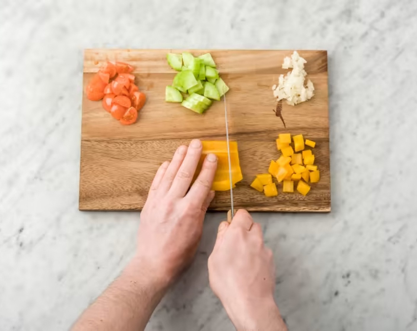 Schritt 2 Zwiebel (1) schälen und würfeln. Tomaten (200 g) waschen und vierteln. Gurken (2) waschen, Enden entfernen, schälen und klein schneiden. Peperoni (2) waschen, entkernen und in Stücke schneiden. Petersilie (20 g) und Basilikum (20 g) waschen, Blätter abzupfen und getrennt voneinander klein schneiden. Rucola (150 g) in einem Sieb waschen, abtropfen lassen und ein wenig zerkleinern.