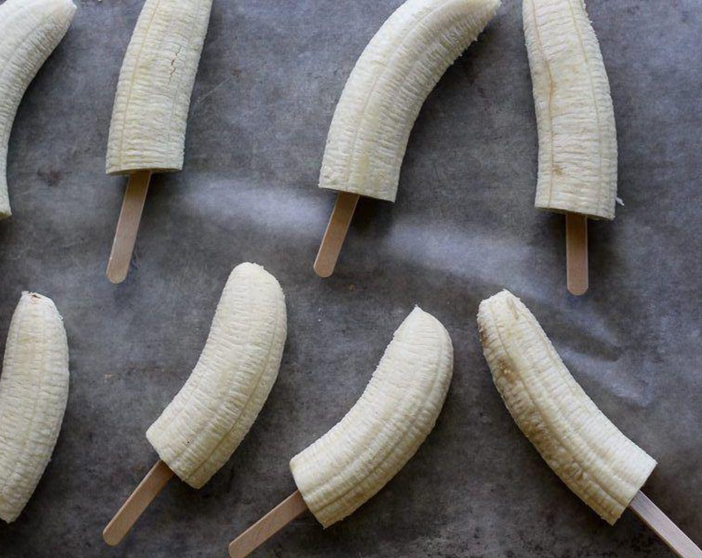 Schritt 1 Bananen (4) schälen und halbieren. Vorsichtig ein Holzstiel in die Mitte jeder Bananenhälfte stecken.