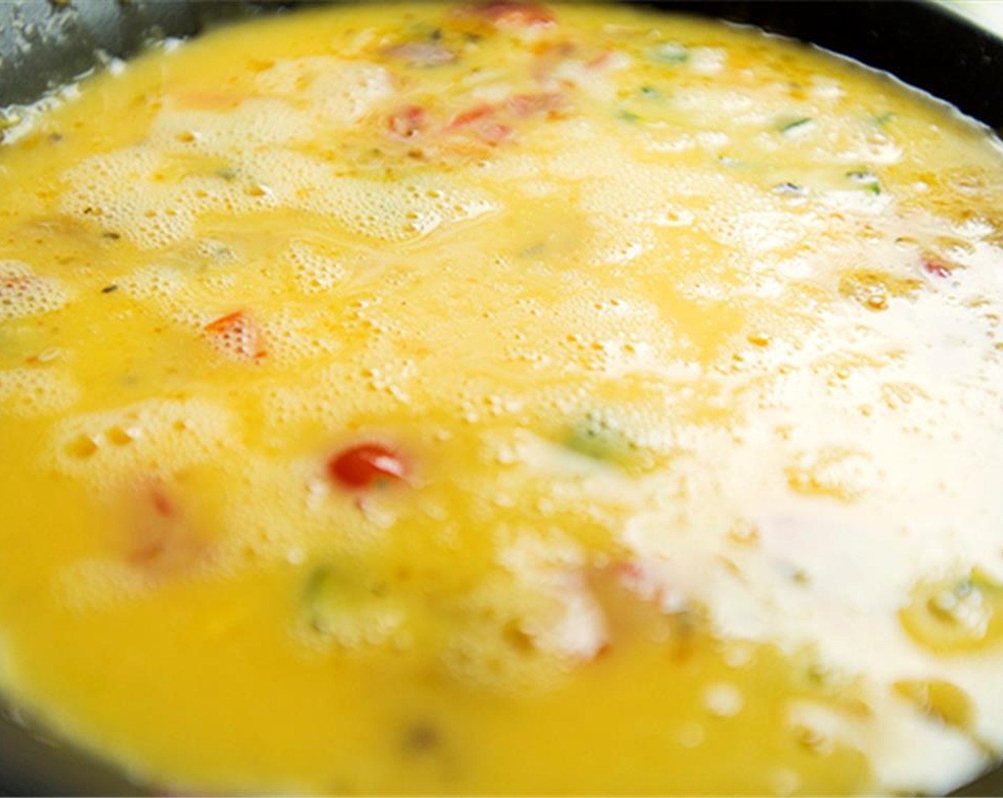 Schritt 5 In einer separaten Schüssel Eier (9) zusammen mit Salz (nach Bedarf) und Pfeffer (nach Bedarf) verquirlen. Die Eimischung in die Pfanne über das Gemüse geben und vorsichtig umrühren.