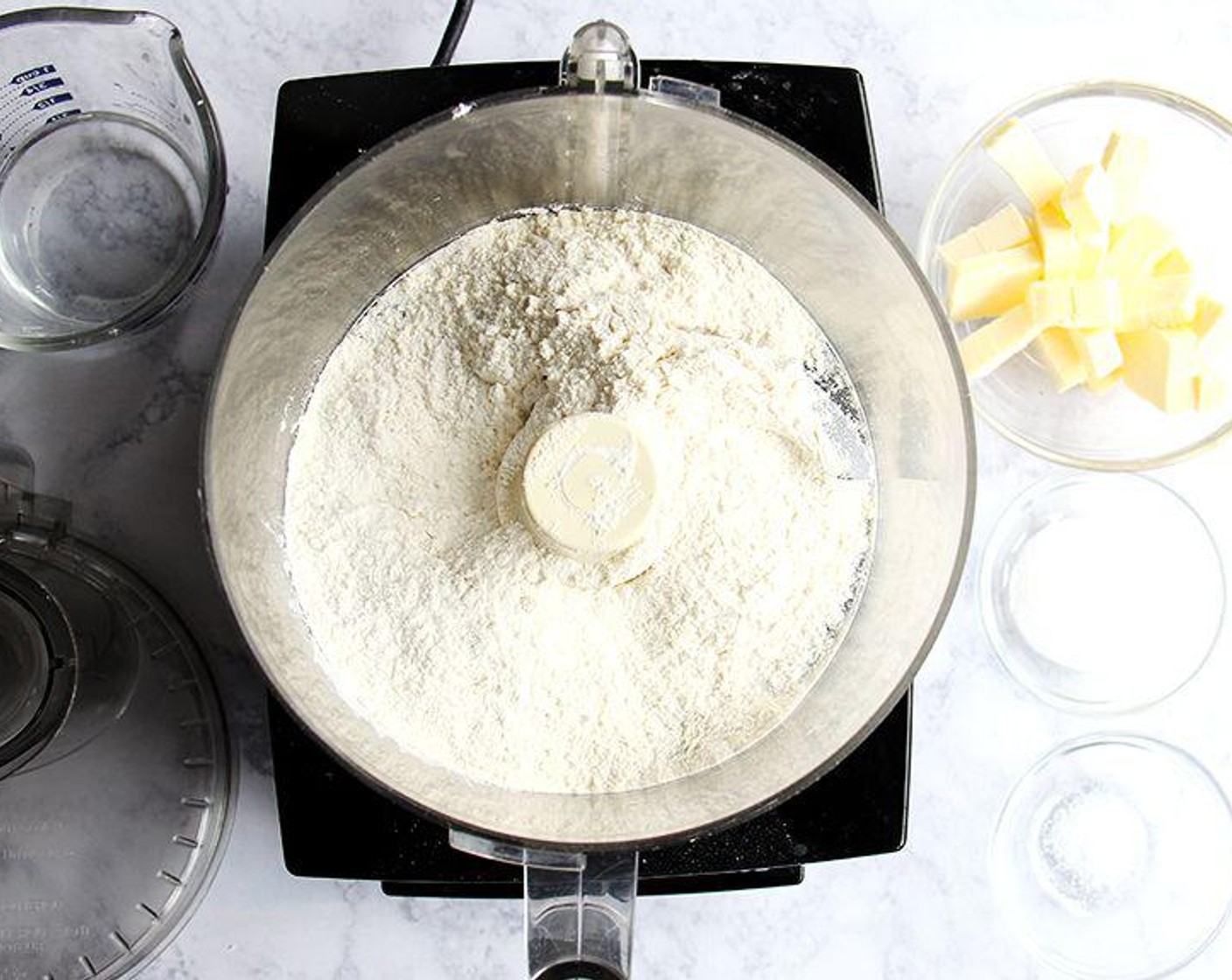 Schritt 1 In der Schüssel einer Küchenmaschine Mehl (600 ml), Zucker (2 Esslöffel), und Kosher Salz (nach Bedarf) zusammen pulsieren. Die Butter, ungesalzen (240 ml) in kleine Stücke schneiden und dann in die Küchenmaschine geben. In 1-Sekunden-Intervallen pulsieren, bis die Butter die Größe von Erbsen hat. Fügen Sie das Wasser (120 ml) hinzu und pulsieren Sie erneut etwa 10 Mal, bis die Mischung krümelig ist, aber zusammenhält, wenn Sie sie zusammendrücken.