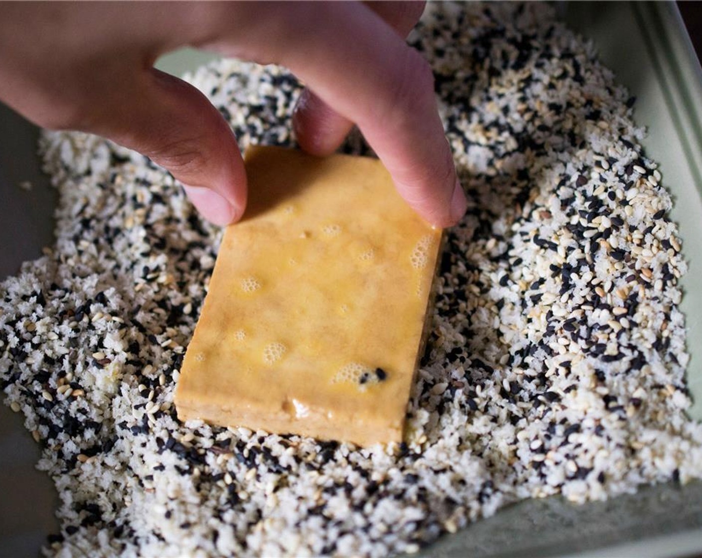 Schritt 7 Anschliessend den Tofu in die Panko-Sesam-Mischung geben, wenden und andrücken, um ihn mit Sesam zu überziehen.
