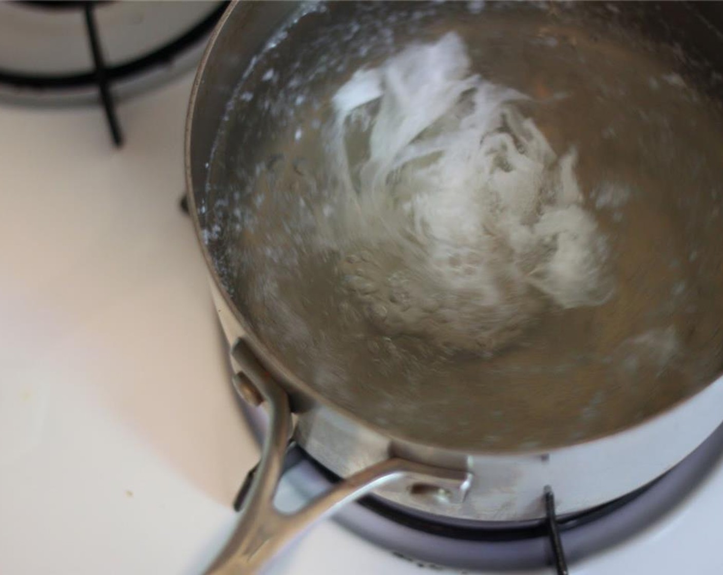 Schritt 9 Wenn das Wasser kocht, Reisessig (2 Esslöffel) hineingeben und umrühren, um einen Strudel zu erzeugen. Dann schnell die Eier (4) in den Strudel aufschlagen. Etwa 3 Minuten kochen, mit einem Schaumlöffel herausnehmen und auf einem Papiertuch abtropfen lassen. Mit allen Eiern wiederholen.