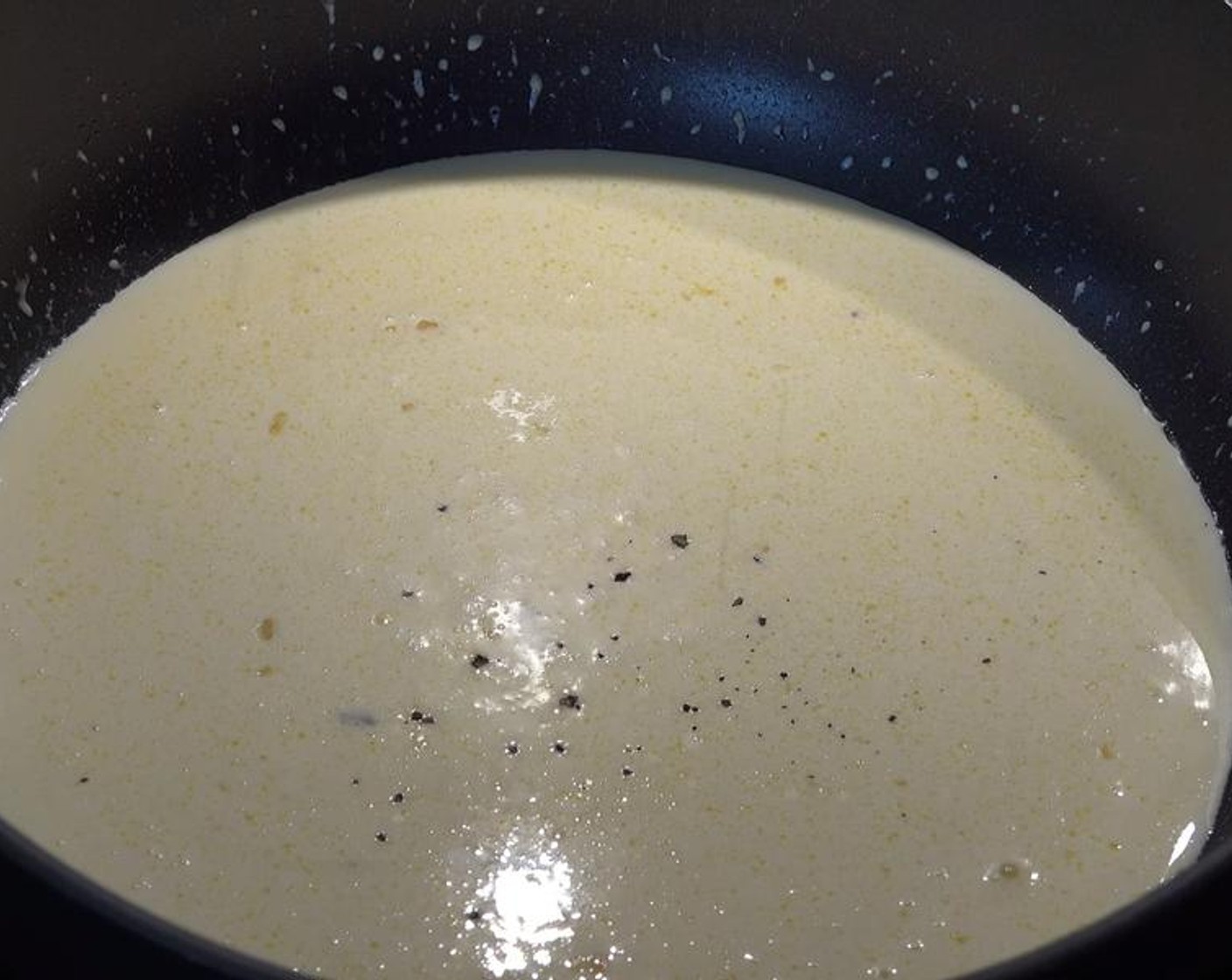 Schritt 4 Rahm (400 ml) dazu giessen und verrühren. Mit Salz (wenig) und Pfeffer (wenig) würzen. Hitze auf niedrige Stufe reduzieren und 4 Minuten lang köcheln lassen, bis die Sauce anfängt einzudicken.