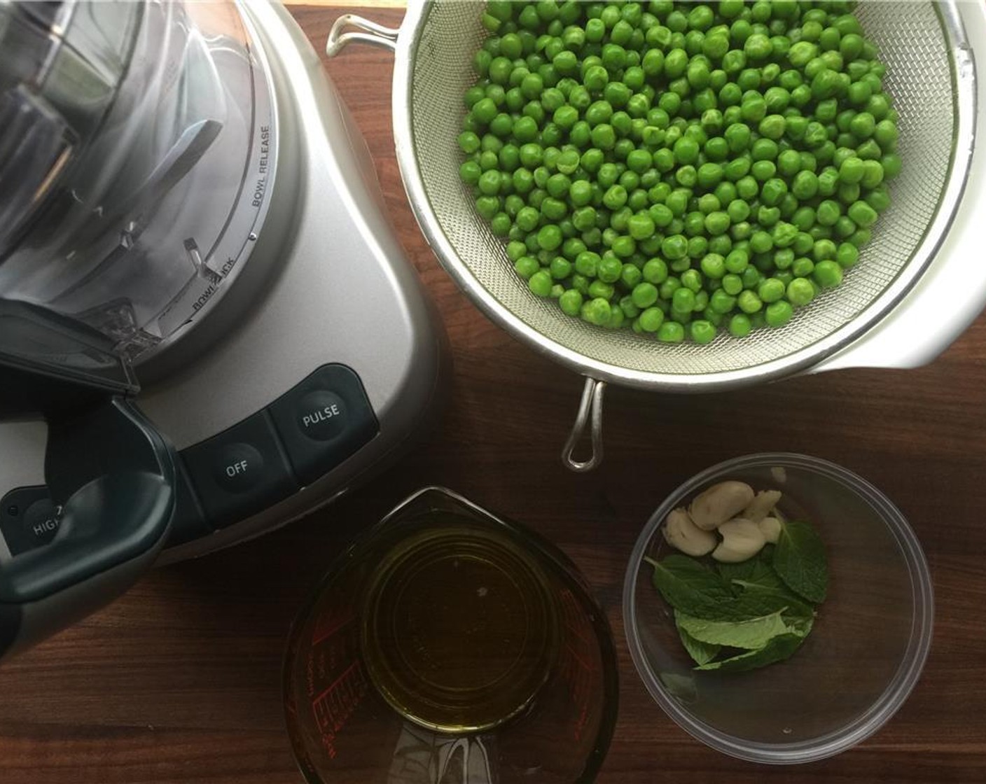 Schritt 1 Erbsen (455 g), Minzblätter (10), Knoblauch (2 Zehen), Salz (nach Bedarf), Pfeffer (nach Bedarf) und Olivenöl (75 ml) in eine Küchenmaschine geben.