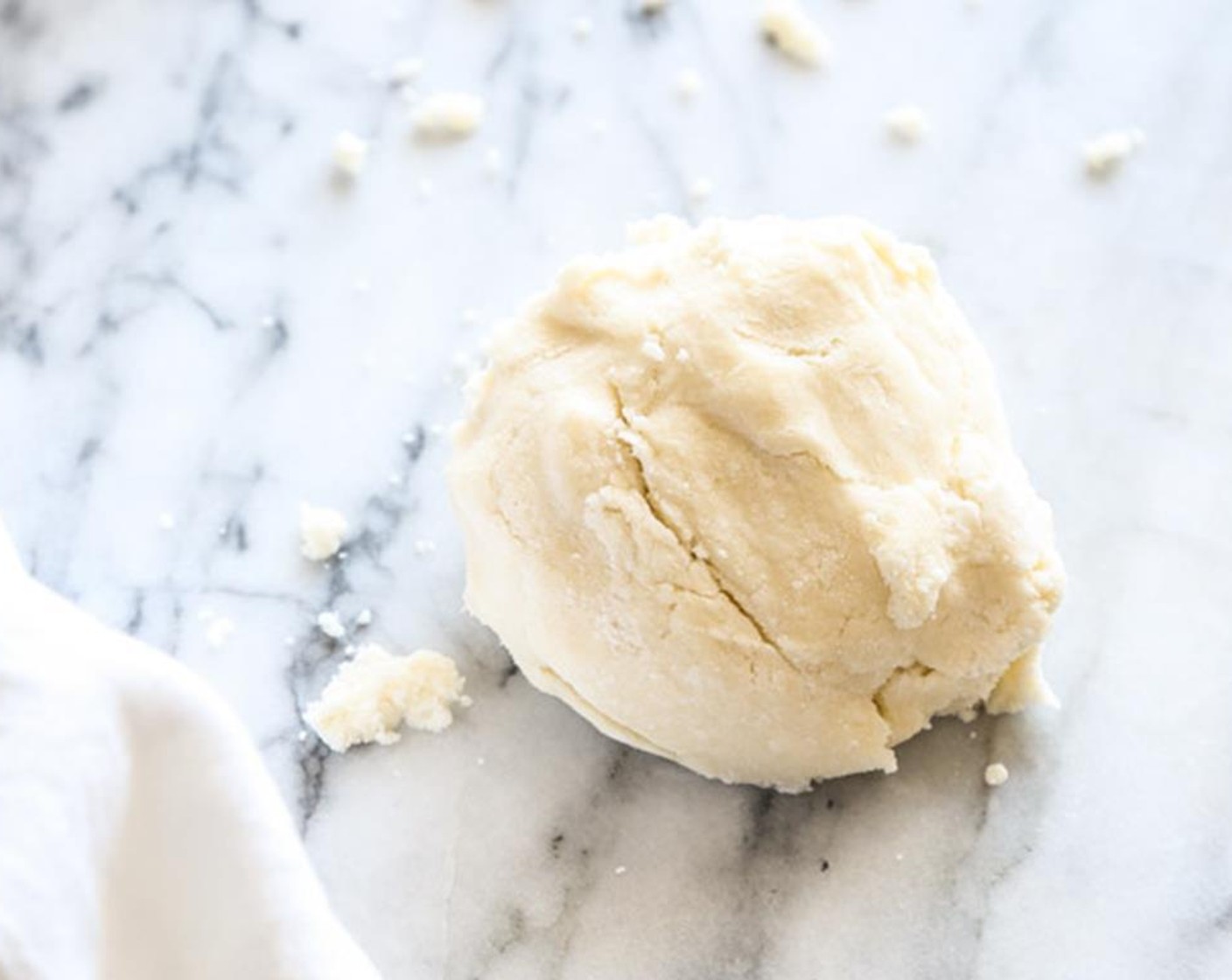 Schritt 3 Tarte-Teig auf eine Arbeitsfläche geben und zu zwei gleich grossen Kugeln formen. Jede Kugel separat in Frischhaltefolie einwickeln und zu einer dünnen Scheibe ausklopfen. 1 Stunde im Kühlschrank kühlen, oder bis zu drei Tage im Voraus vorbereiten.