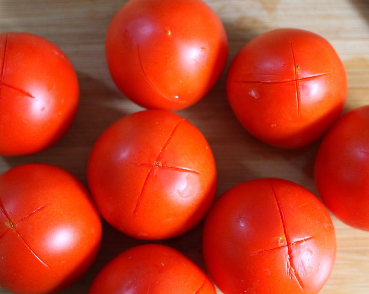 Schritt 1 Tomaten (8) waschen und mit einem Messer ein "X" in den Boden jeder Tomate einschneiden.
