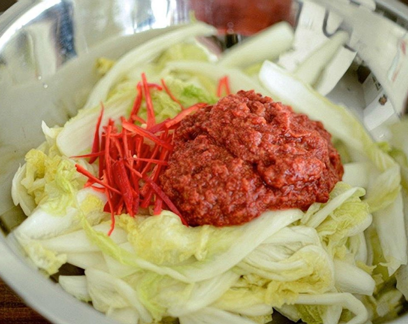 Schritt 13 Abgetropfte Kohlblätter in eine grosse flache Schüssel legen. Die Chilis (falls verwendet) und die Kimchi-Füllung darüber geben.