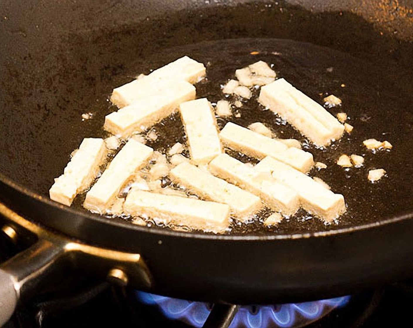 Schritt 8 Tofu und Knoblauch hinzufügen. Etwa 45 Sekunden anbraten, dabei häufig umrühren. Der Knoblauch sollte leicht braun werden, darf aber nicht verbrennen!