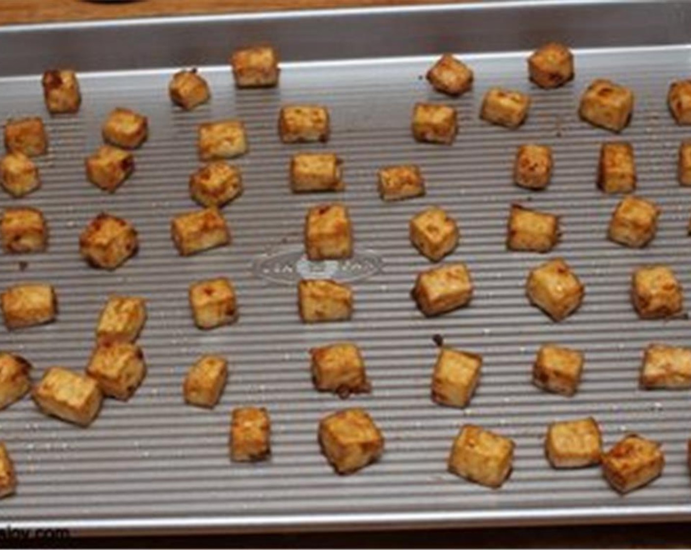 Schritt 4 Tofu mit etwas Abstand auf ein Backblech legen und im vorgeheizten Backofen bei 175 °C für etwa 30 bis 40 Minuten backen. Nach der Hälfte der Zeit wenden.