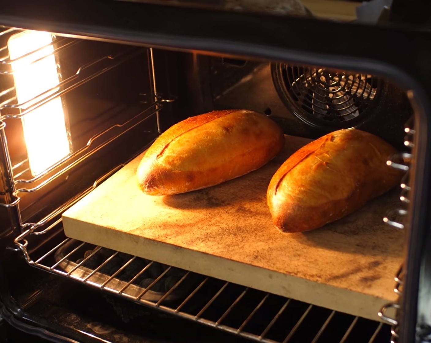 Schritt 14 Nach 20 Minuten die Schüssel mit Wasser aus dem Ofen nehmen bzw. den Dampf ablassen, die Ofentemperatur auf 190 °C reduzieren und die Brote für weitere 20-25 Minuten goldgelb fertig backen.