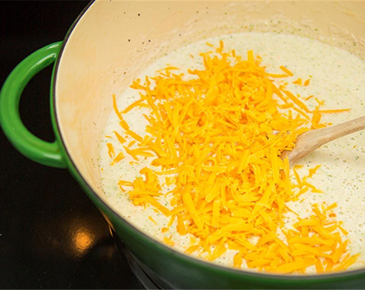 Schritt 7 Cheddar, gelb, mild (140 g) und Cheddar Käse, weiss (150 g) in die Suppe geben und bei mittlerer Hitze einrühren, bis er geschmolzen ist.