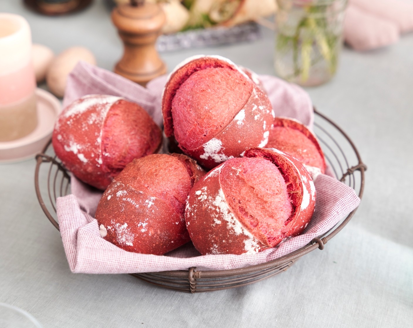 Schritt 4 Die Brötchen vom Tuch nehmen und umgedreht (mit dem Schluss nach unten) mit etwas Abstand auf einem mit Backpapier ausgelegten Backblech verteilen. Kurz vor dem Backen mit einem sehr scharfen Messer oder einer Rasierklinge längs oder kreuzweise ca. 1 cm tief einschneiden. Das Blech in den Ofen (Mitte) geben, Wasser (100 ml) in die feuerfeste Schale giessen und sofort die Backofentür schliessen (Vorsicht, es kann spritzen!). Die Brötchen 10 Minuten backen, dann die feuerfeste Schale entfernen und Brötchen weitere 12–15 Minuten knusprig braun backen. Aus dem Ofen nehmen und auf einem Kuchengitter abkühlen lassen.