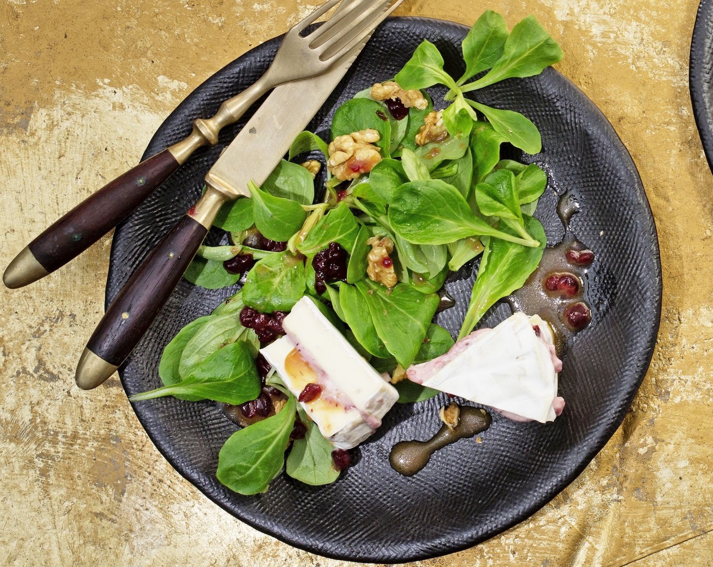 Schritt 4 Den Nüsslisalat (120 g) auf den Tellern zusammen mit dem Camembert anrichten und mit der Vinaigrette beträufeln. Zum Schluss die Walnüsse (40 g) darüber verteilen und direkt geniessen.