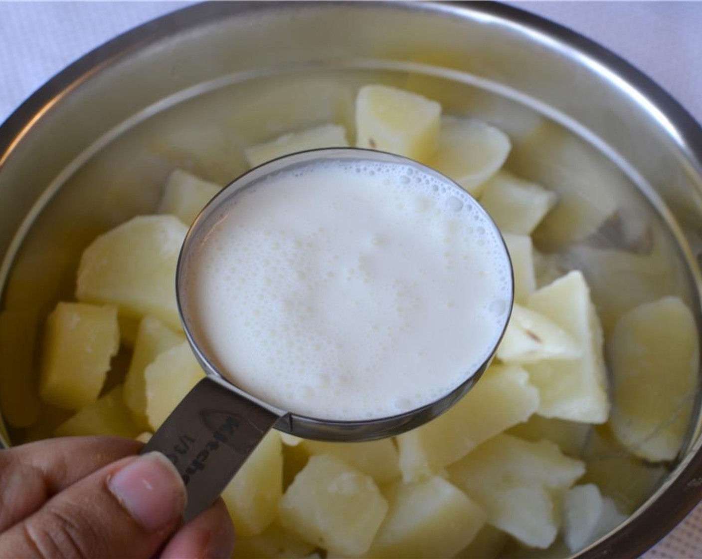 Schritt 9 Butter (3 Esslöffel) und Vollrahm (160 ml) zu den heissen Kartoffeln geben. Die Kartoffeln mit einem Kartoffelstampfer zerdrücken. Mit Salz und Pfeffer ( wenig) würzen.