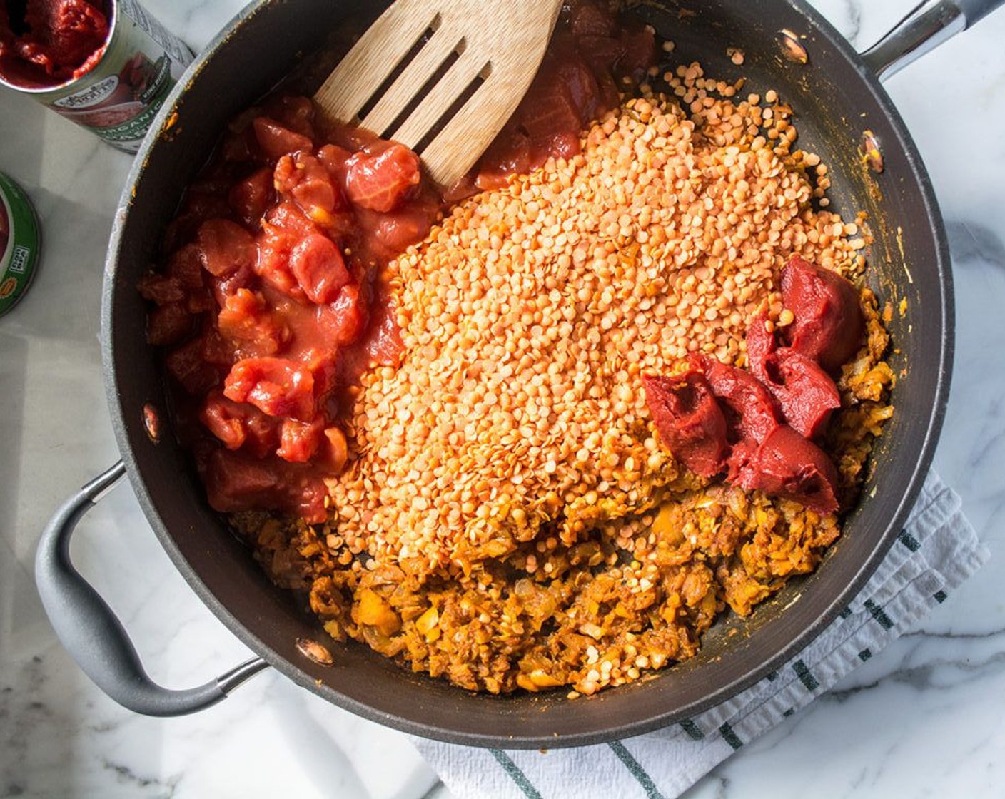 Schritt 10 Linsen (270 g), Dosentomaten (410 g), Tomatenmark (80 g) und Gemüsebouillon (800 ml) hinzufügen. Umrühren und zum Kochen bringen.