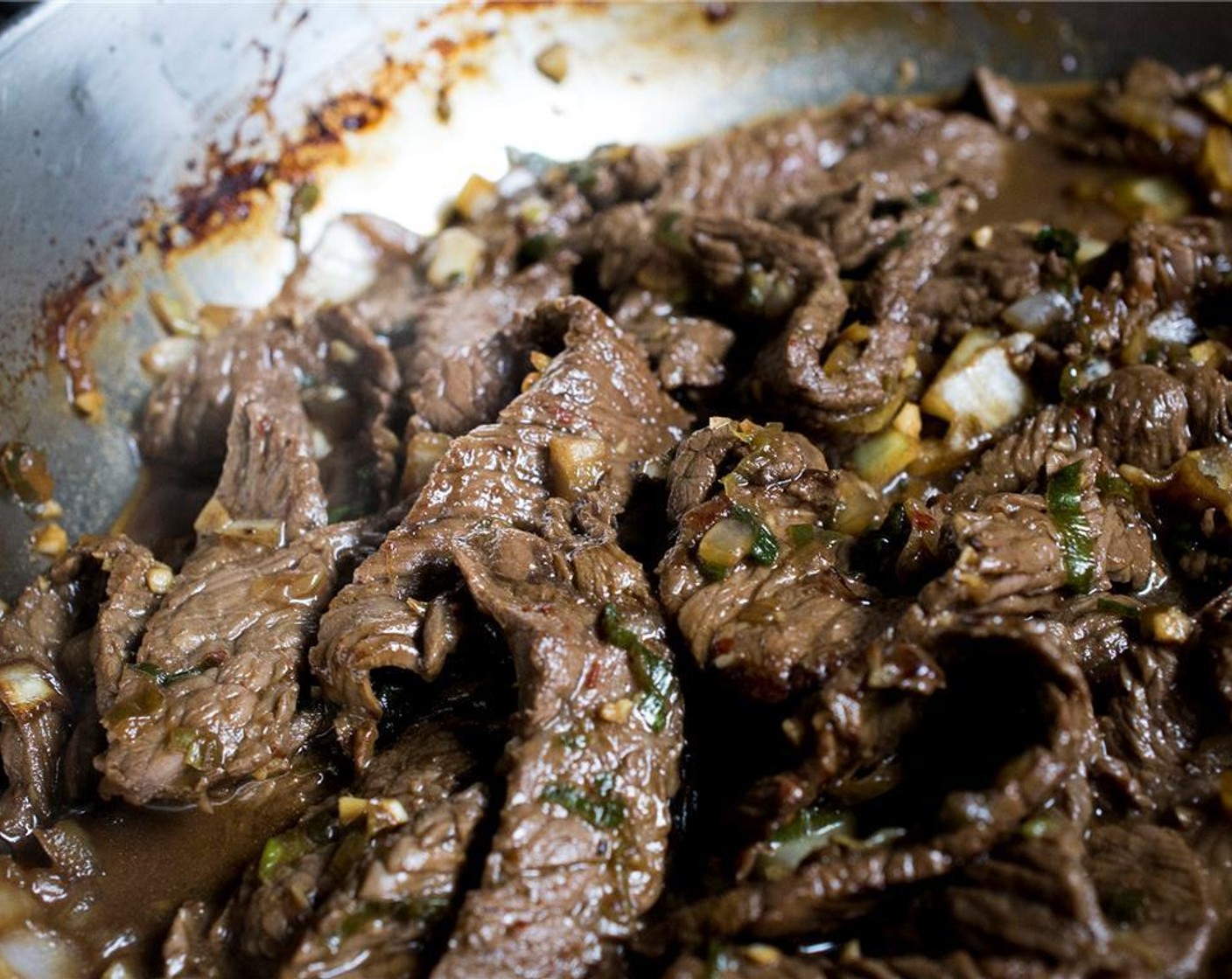 Schritt 9 Das Öl (2 Esslöffel) in einer grossen Pfanne bei mittlerer bis hoher Hitze erwärmen. Das aus der Marinade abgetropfte Rindfleisch in die Pfanne geben (portionsweise anbraten, falls die Pfanne zu klein ist). 1 Minute braten (dabei das Rindfleisch nicht wenden). Mit einer Prise Salz würzen, dann mit dem Rühren beginnen und das Rindfleisch für 1 - 2 Minuten schwenken, bis es gar ist. Vom Herd nehmen und beiseitestellen.