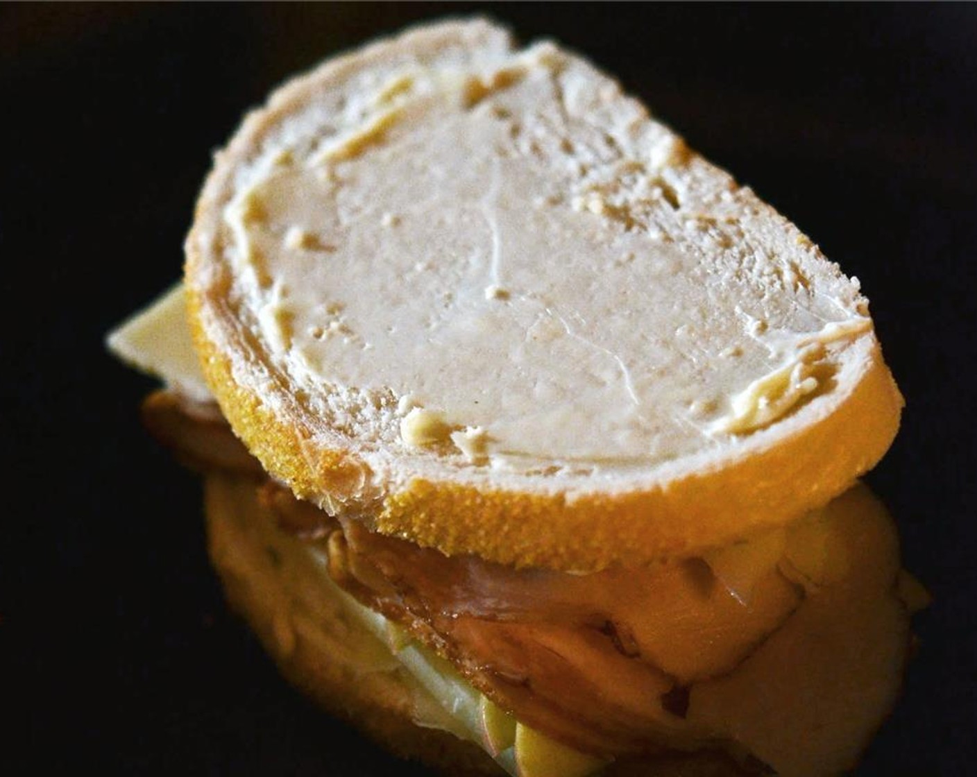 Schritt 5 Den übrigen Senf (2 Teelöffel) auf die andere ungebutterte Brotscheibe streichen. Das Brot mit der Butterseite nach oben auf das Sandwich legen.