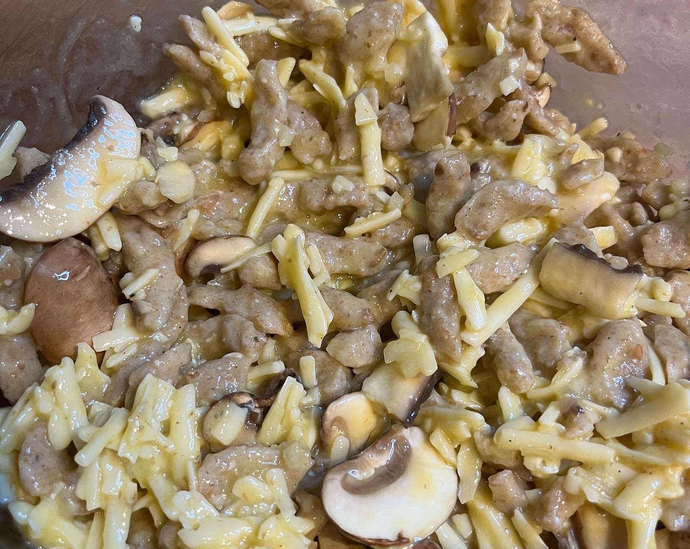 Schritt 2 Spätzle (300 g), Eier (6), Pilze, Zwiebeln und 120 g vom Käse in einer Schüssel vermengen. Mit Salz (wenig) und Pfeffer (wenig) würzen.