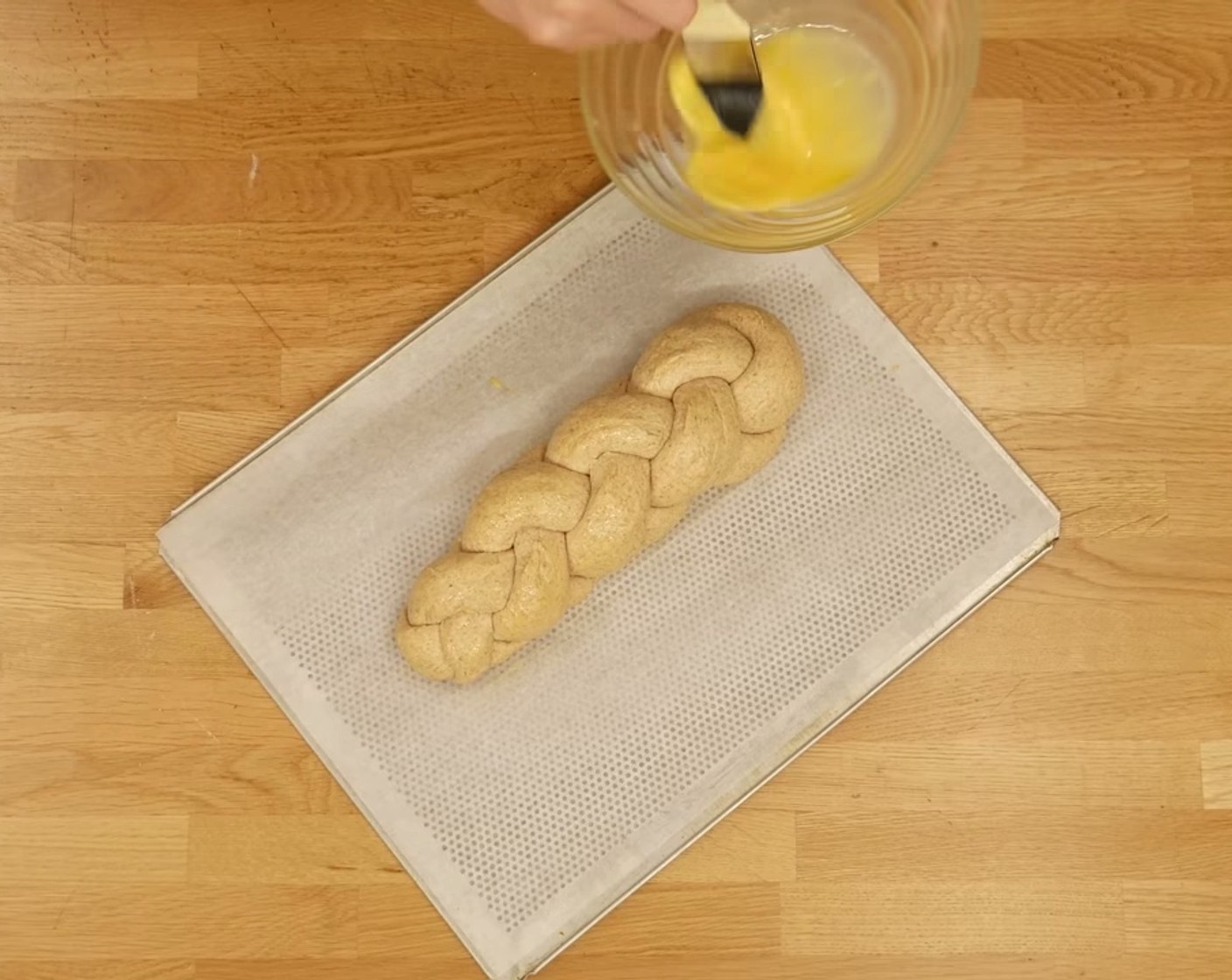 Schritt 12 Nach der Gärzeit den Zopf nochmals mit dem Ei bestreichen und dann in den vorgeheizten Ofen schieben und für 2-3 Minuten bei 200 °C anbacken.