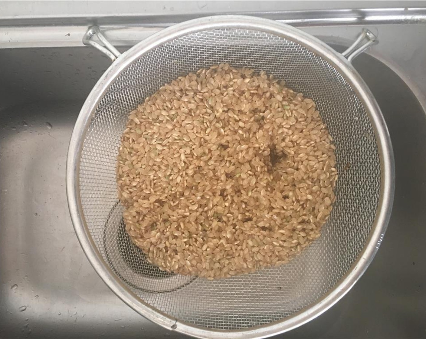 Schritt 1 Braunen Reis (370 g) in einem Sieb abspülen, bis das Wasser klar ist.