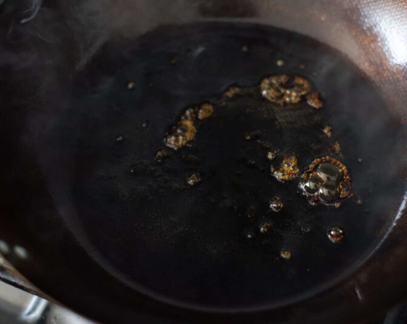 Schritt 3 Rapsöl (2 Esslöffel) in einer tiefen Pfanne oder einem Wok bei starker Hitze erhitzen. Zucker (2 Teelöffel) hinzugeben und in der Pfanne schwenken. Den Zucker braun werden lassen und karamellisieren.