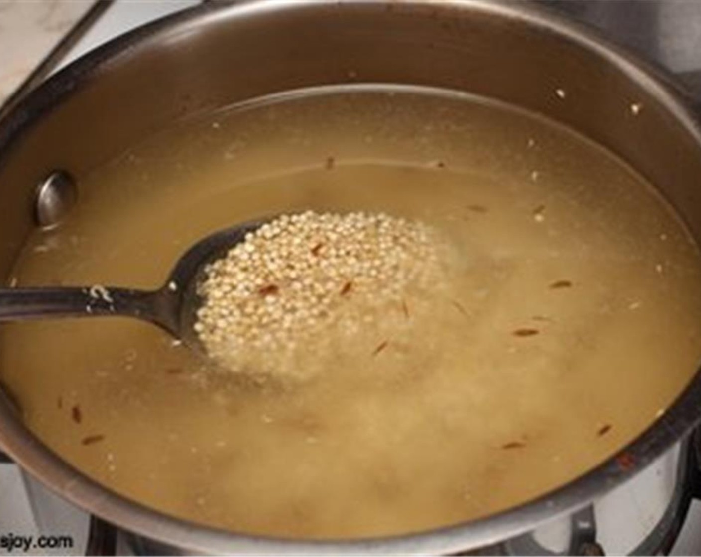 Schritt 5 Während der Tofu backt, Olivenöl (1 TL) in einem mittelgrossen Topf erhitzen. Kreuzkümmel (nach Bedarf) zusammen mit Quinoa (210 g) und Wasser (600 ml) hinzufügen.