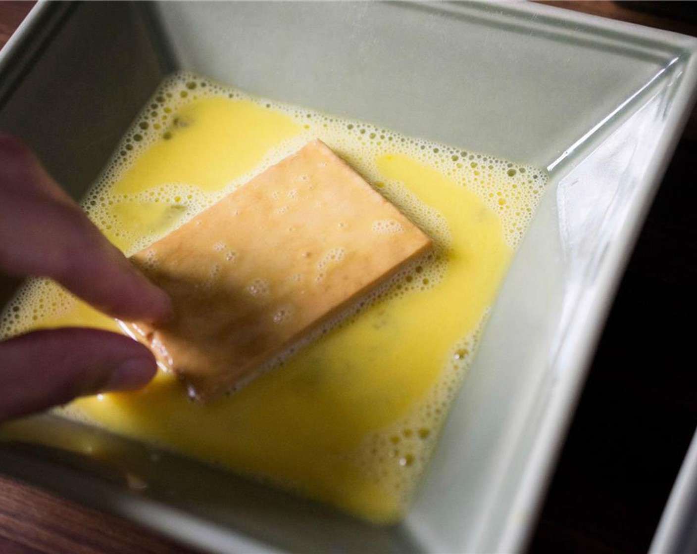 Schritt 6 Den Tofu jeweils mit einer Scheibe in die Eimischung tauchen, darauf achten, dass das gesamte Stück bedeckt ist.