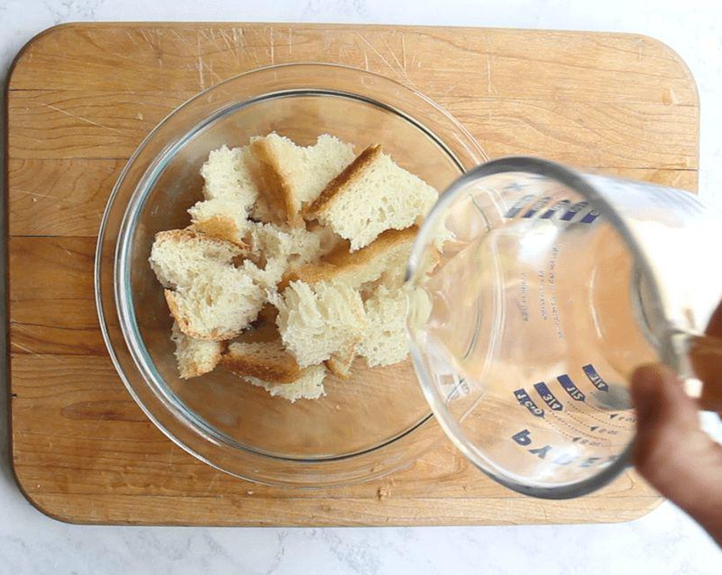 Schritt 2 In der Zwischenzeit in einer kleinen Schüssel Wasser (80 ml) über das zerkleinerte Brot (2 Scheiben) giessen. Etwa 10 Minuten einziehen lassen, bis es weich wird.