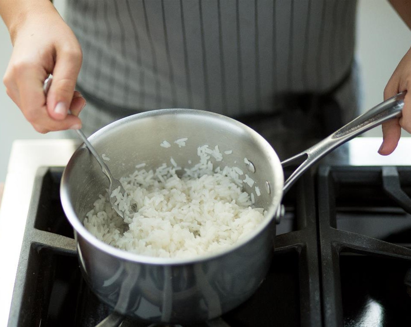 Schritt 4 Jasmin-Reis (115 g) und Wasser (240 ml) in einem kleinen Kochtopf bei mittlerer bis hoher Hitze vermengen. Wenn das Wasser kocht, umrühren, den Deckel auflegen, die Hitze reduzieren und 15 Minuten köcheln lassen. Den Reis mit einer Gabel auflockern und zum Anrichten warm halten.