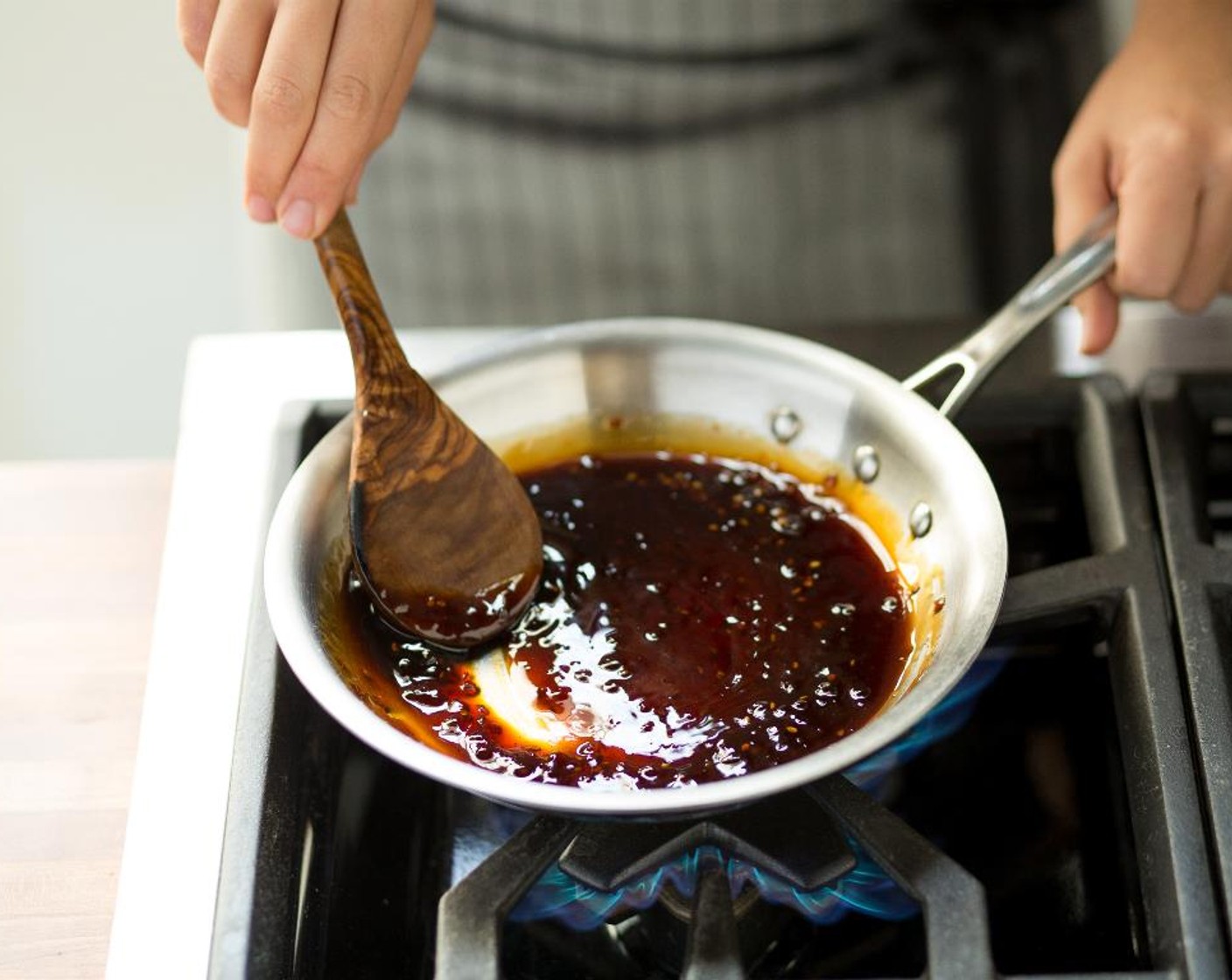 Schritt 9 Sobald die Sauce zu kochen beginnt, die Hitze auf niedrige Stufe reduzieren und für 3 bis 4 Minuten köcheln lassen, bis die Sauce eingedickt und um die Hälfte reduziert ist. Den Honig (3 Esslöffel) einrühren.