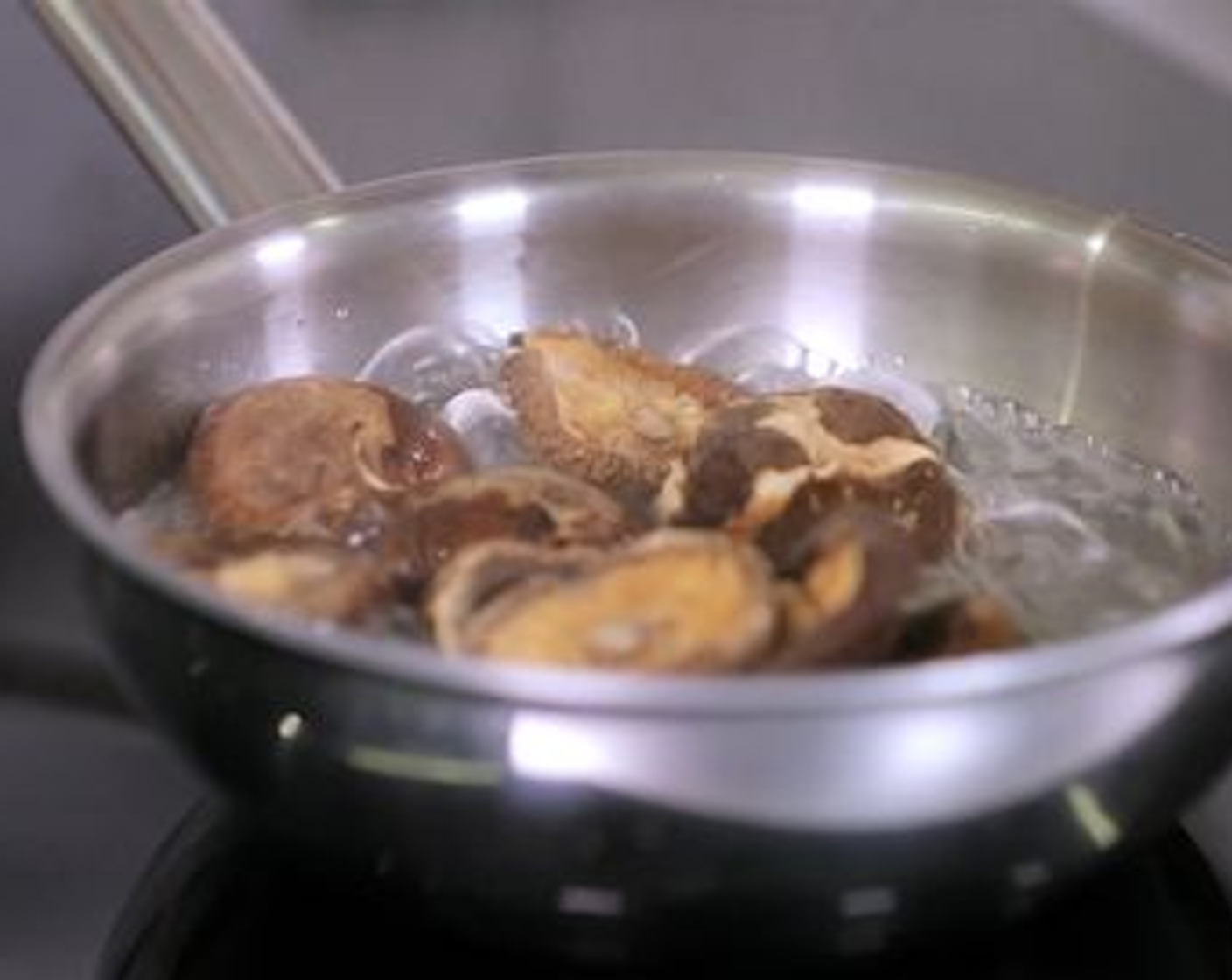 Schritt 1 Das Wasser (500 ml) in einer Pfanne aufkochen, die getrockneten Pilze (10) beifügen, die Pfanne von der Herdplatte nehmen und die Pilze für 10 Minuten einweichen lassen.