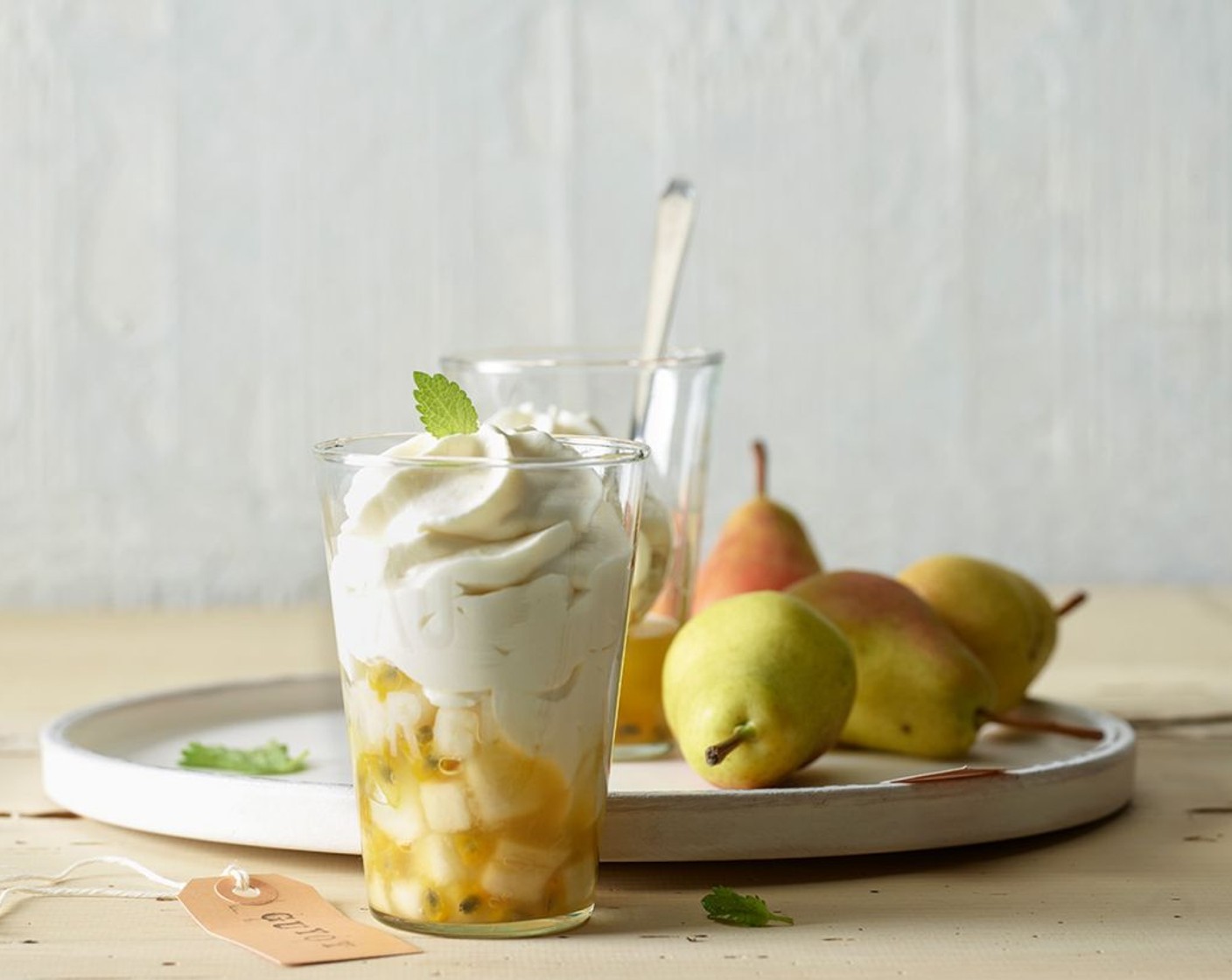 Schritt 6 Zum Servieren das Birnen-Passionsfrucht-Kompott in Schalen oder Gläser verteilen. Den Rahmbläser nochmals kräftig schütteln und den Schaum auf das Kompott spritzen.