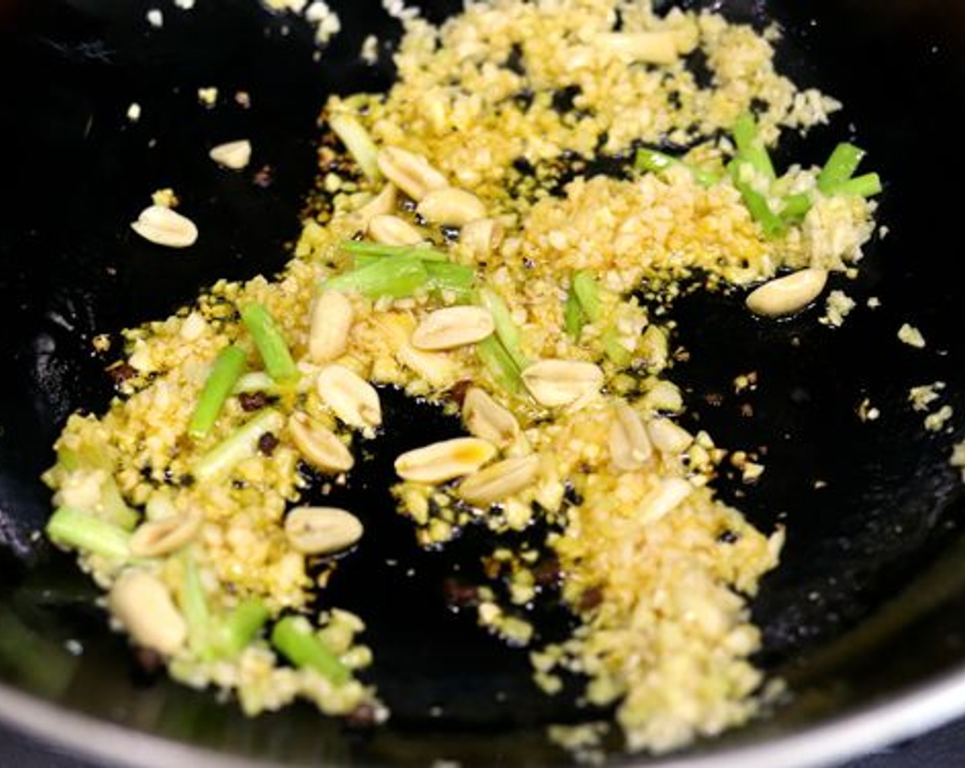 Schritt 10 Erdnüsse (1 EL) und Szechuan-Pfefferkörner (nach Bedarf) hinzugeben. Die Erdnüsse etwa 20 Sekunden im Wok bräunen lassen, bevor sie geschwenkt werden.