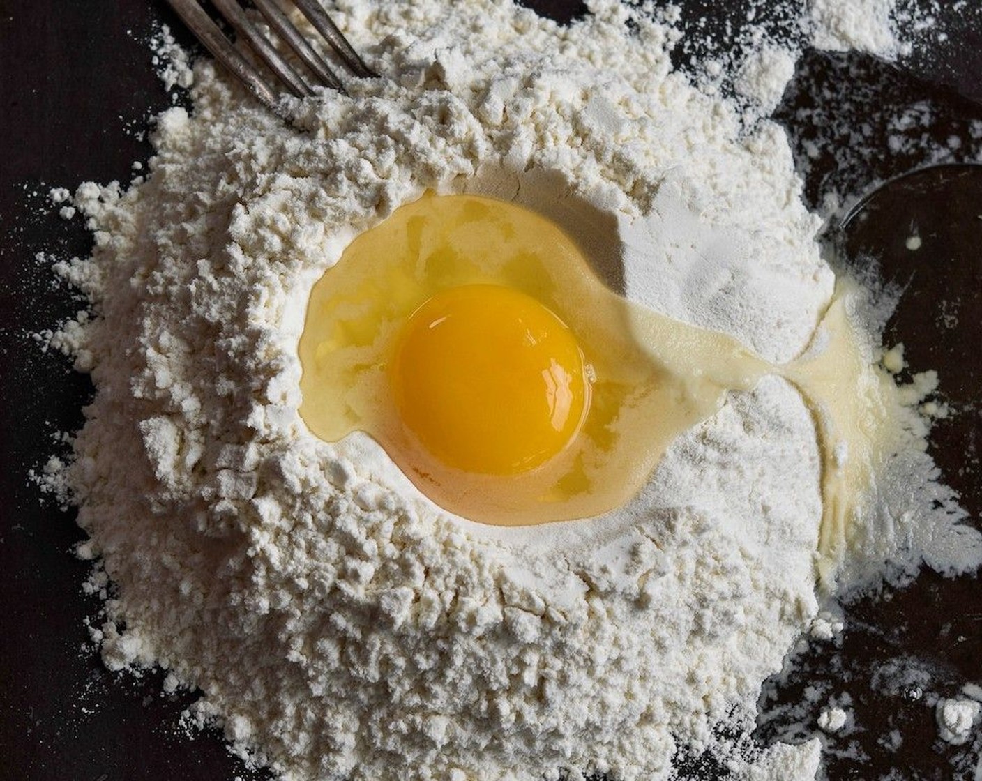 Schritt 5 Für den Nudelteig, Mehl (400 g) sieben und eine Salz (wenig) hinzufügen. Auf einer ebenen Fläche das Mehl ausstreichen und in der Mitte eine Vertiefung machen. Die Eier (4) schlagen und hineingeben und mit einer Gabel in das Mehl einarbeiten, bis ein klebriger Teig entsteht.