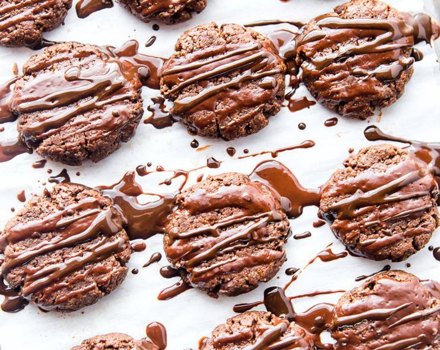 Schritt 7 Während die Kekse abkühlen, zusätzliche dunkle Schokolade (wenig) schmelzen. Anschliessend die dunkle Schokolade über die Cookies träufeln und mit Haselnüssen (wenig) bestreuen.