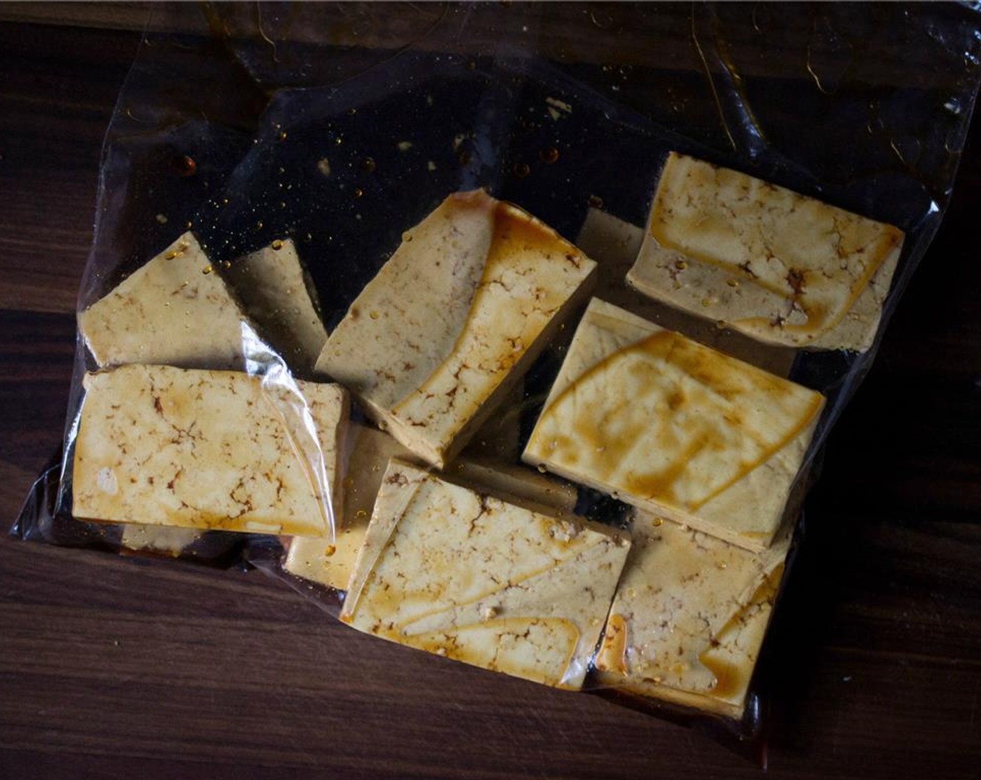 Schritt 3 Die Tofuscheiben hinzufügen, den Beutel verschliessen und den Tofu vorsichtig bewegen, um ihn zu überziehen. Mindestens 30 Minuten marinieren lassen, dabei den Beutel regelmässig wenden, damit der Tofu von allen Seiten bedeckt ist.