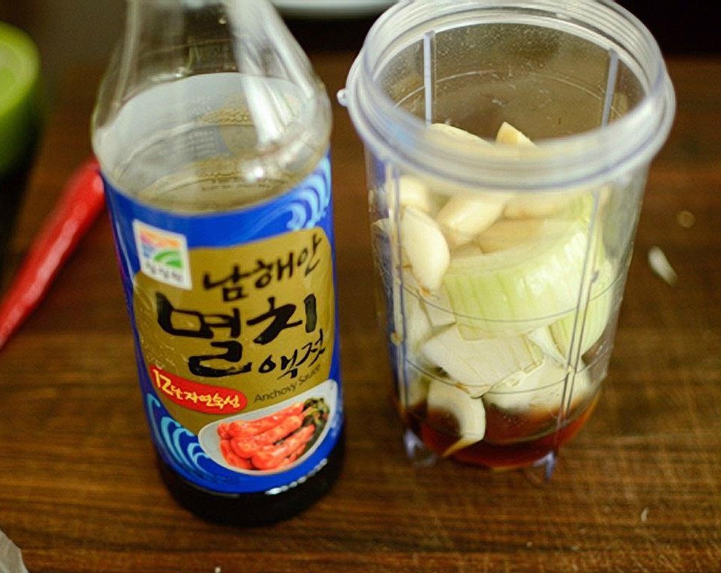 Schritt 10 Für die Kimchi-Füllung Knoblauch (5 Zehen), Ingwer (2 cm), Zwiebel und Sardellen Sauce (3 Esslöffel) in einem kleinen Mixer glatt pürieren.