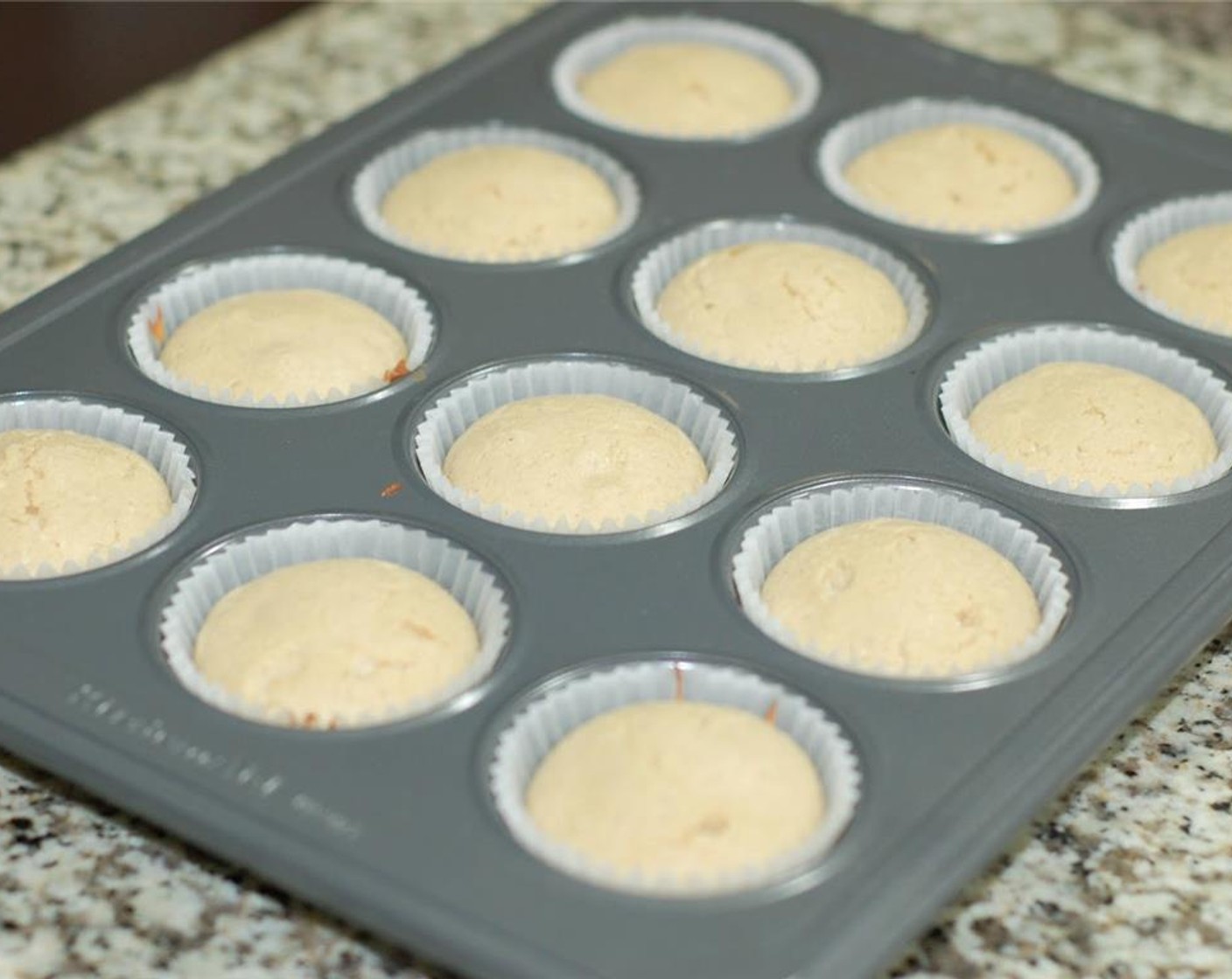 Schritt 5 Muffinform mit Papier auslegen. Den Teig gleichmässig in jedes Muffinförmchen etwa zur Hälfte füllen.