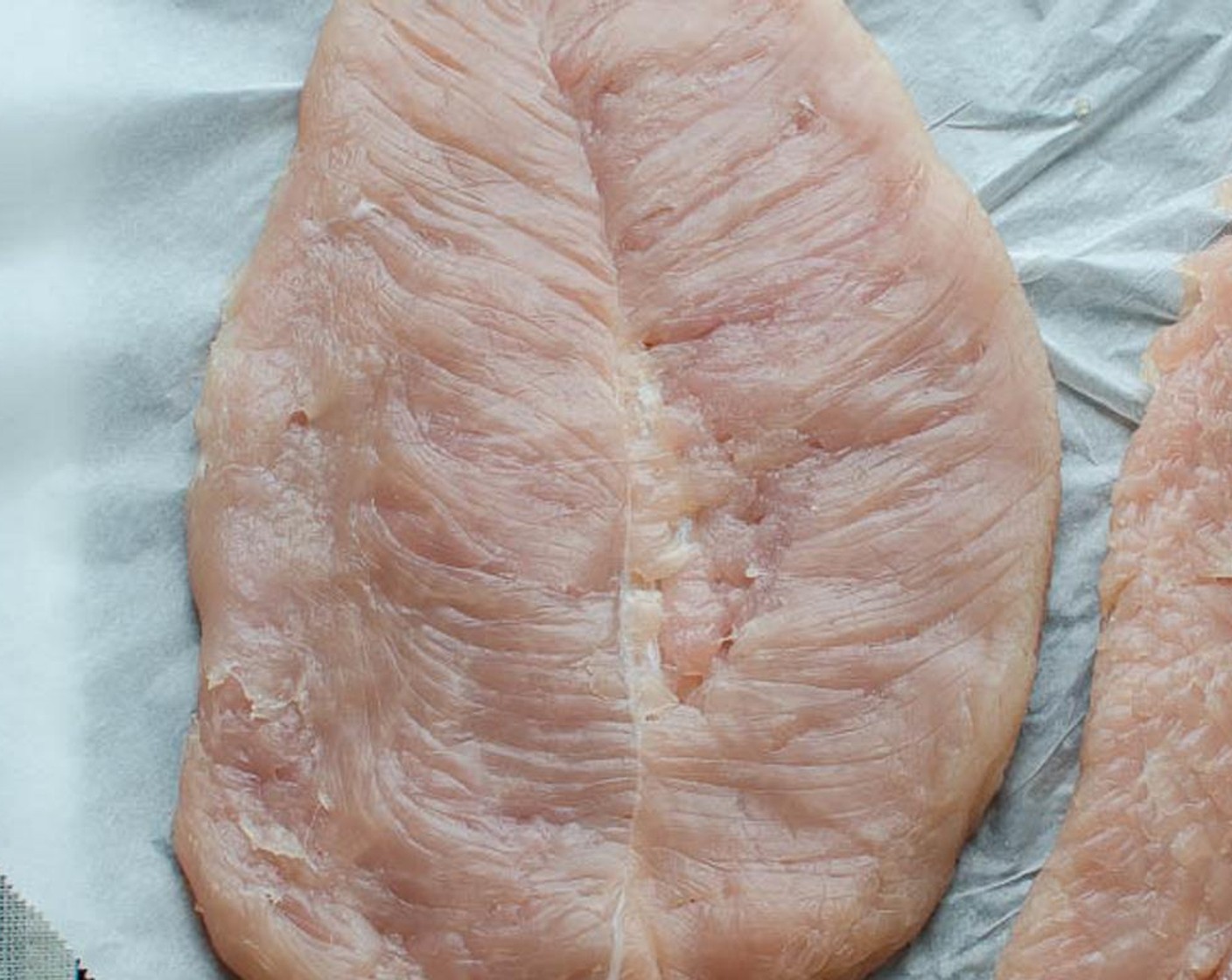 Schritt 7 Mit der flachen Seite eines Fleischklopfers auf das Fleisch einklopfen, bis es etwa 0.8 cm dick ist. Darauf achten, dass das Fleisch nicht einreisst. Beiseite stellen und mit dem zweiten Filet fortfahren. Beiseite stellen.