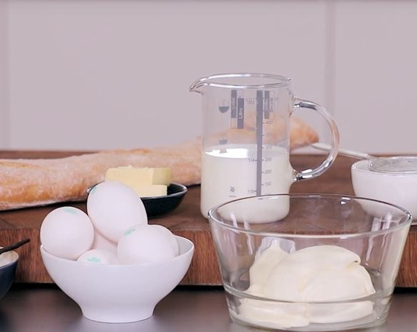 Schritt 1 Form grosszügig mit Butter (2 Esslöffel) einfetten. Dann die Vanilleschote (1) auskratzen. Eier (6), Zucker (200 g), Milch (250 ml), Rahm (500 ml), Vollrahm (250 ml) und Vanillemark gründlich mit einem Pürierstab vermischen.