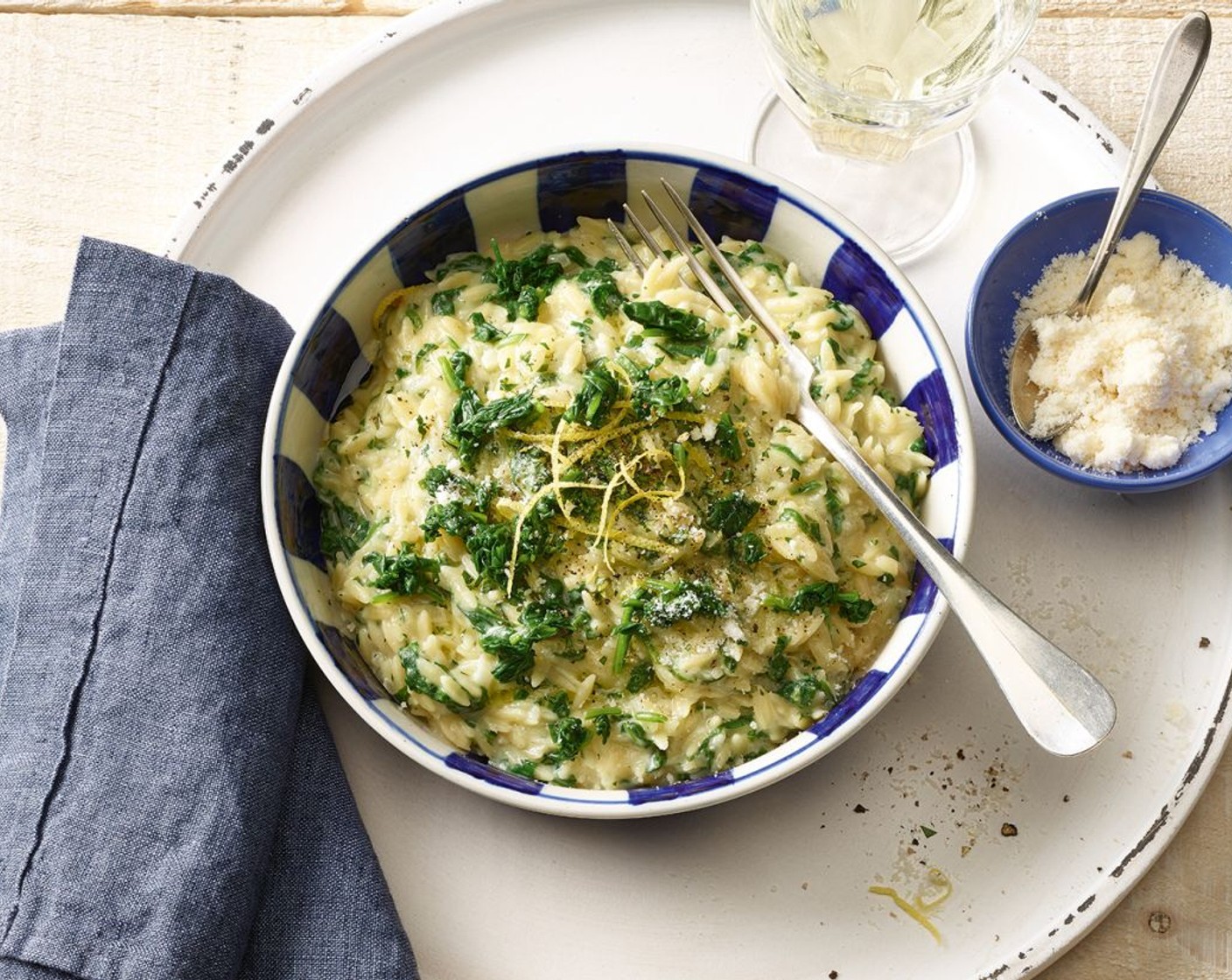 Schritt 6 Am Ende der Kochzeit des Orzo-Risottos den Spinat, die Petersilie, den geriebenen Parmesan (80 g) die Zitronenschale sowie 1 Esslöffel Saft beifügen. Den Risotto wenn nötig mit Salz (wenig), Pfeffer (wenig) und wenig Zitronensaft abschmecken. Sofort servieren.