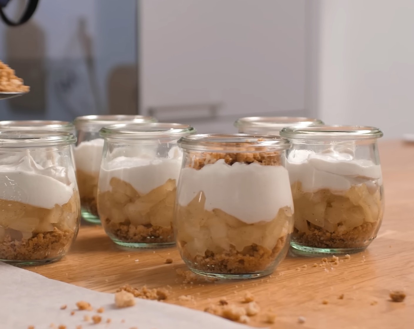 Schritt 11 Als nächste Schicht etwas der Creme auf die Äpfel spritzen und schliesslich die restlichen Streusel auf der Creme verteilen.