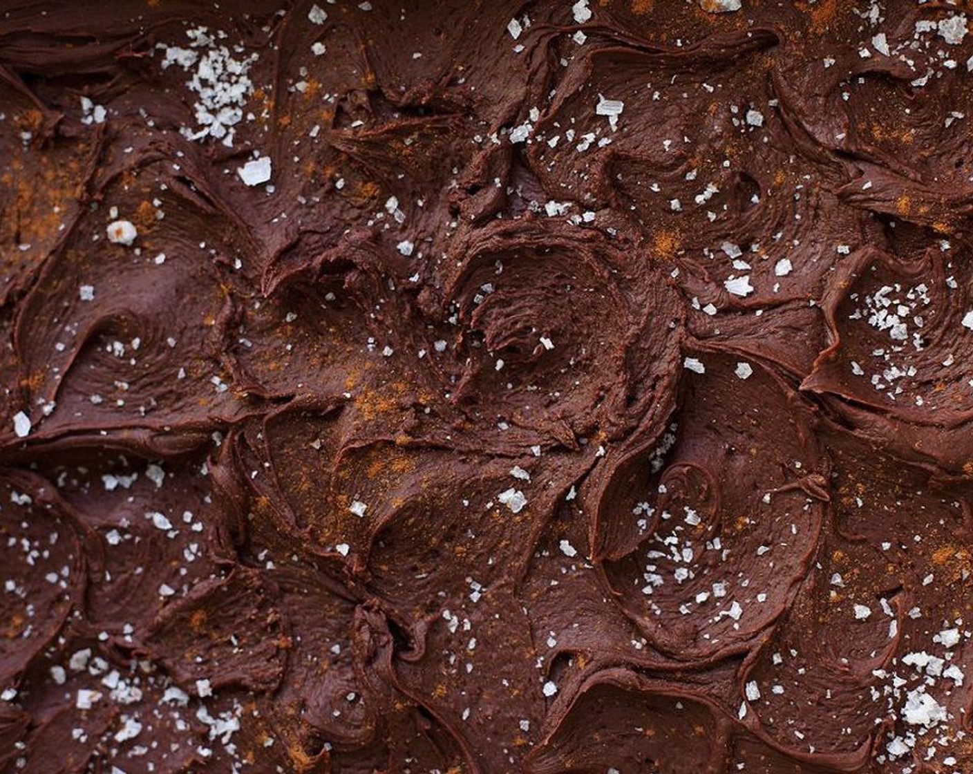 Schritt 9 Den Fondant über die Brownies giessen. Die Brownies dürfen noch warm, aber nicht heiss sein. Mit der Rückseite eines Löffels glatt streichen und Strudel bilden.