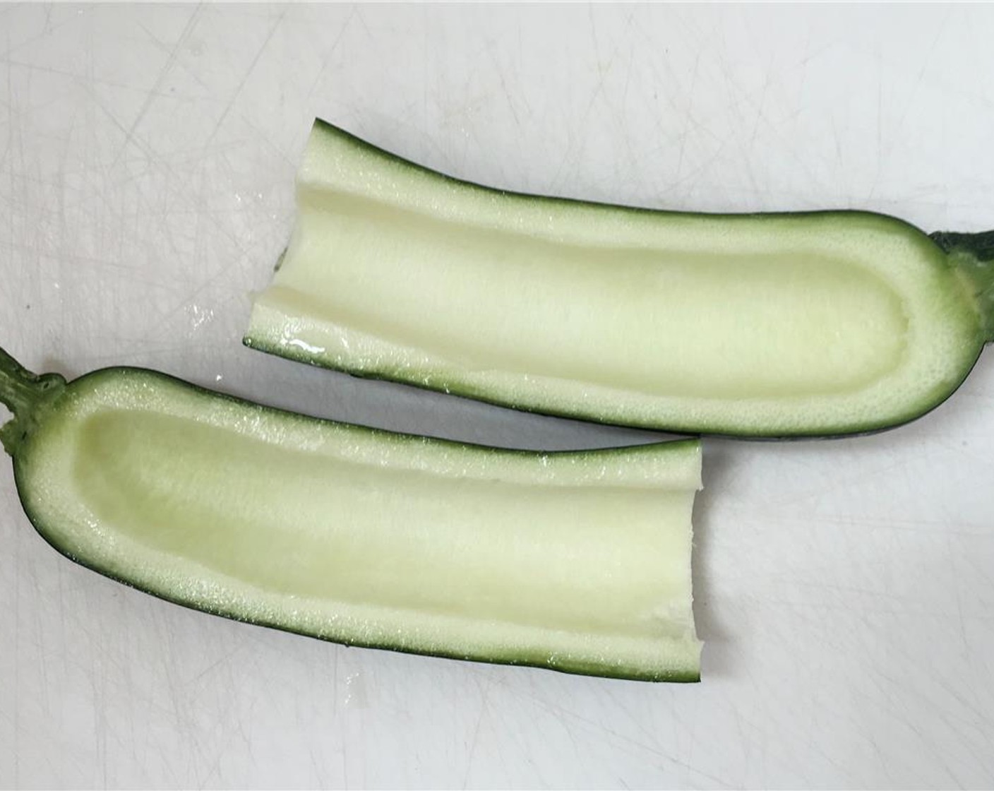 Schritt 2 Zucchini (1) der Länge nach halbieren. Das weiche Innere mit einem Teelöffel entfernen.