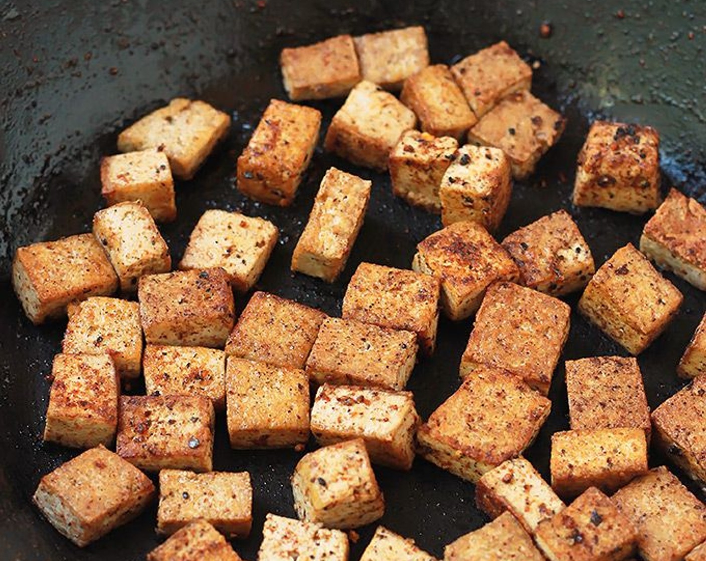 Schritt 2 Eine grosse Pfanne bei mittlerer Hitze erhitzen, Olivenöl (2 Teelöffel) in die Pfanne geben und Tofu portionsweise anbraten. Gebratenen Tofu beiseitestellen.