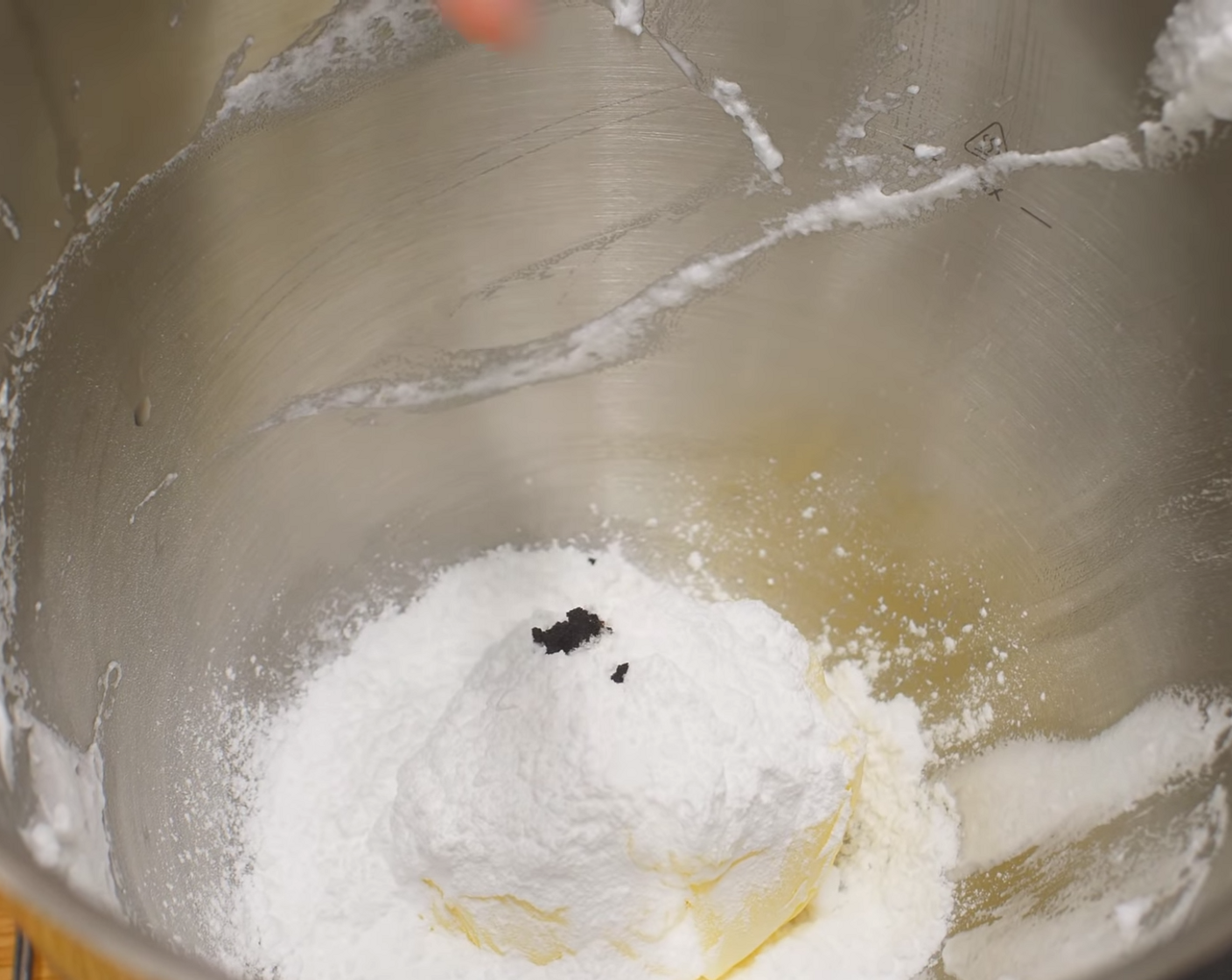 Schritt 2 Danach die weiche Butter (190 g) mit dem Puderzucker (100 g) und dem Samen der Vanilleschote (1) schaumig schlagen. Die Eigelbe einzeln nach und nach dazugeben und weiter schlagen. Die Orangenschalen (wenig) zur Milch (50 g) und zusammen zur Buttermasse geben und gut verrühren.