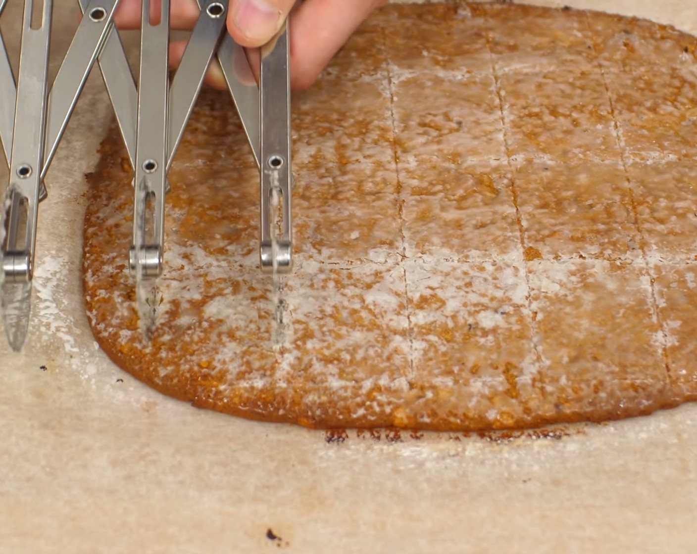 Schritt 13 Nach dem Erkalten wird der Zucker „absterben“ und die Läckerli bekommen die typischen und unregelmässigen weissen Stellen. Das Backpapier mit der Läckerliplatte vom Blech auf die Arbeitsplatte ziehen und mit einem Ruck-Zuck (Teigschneider) Rechtecke von 5cm x 4cm markieren und einem Pizzarad schneiden.